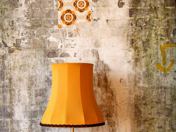 Shabby-Chic-Zimmer mit einer orangefarbenen Lampe und orangener Wanddekoration